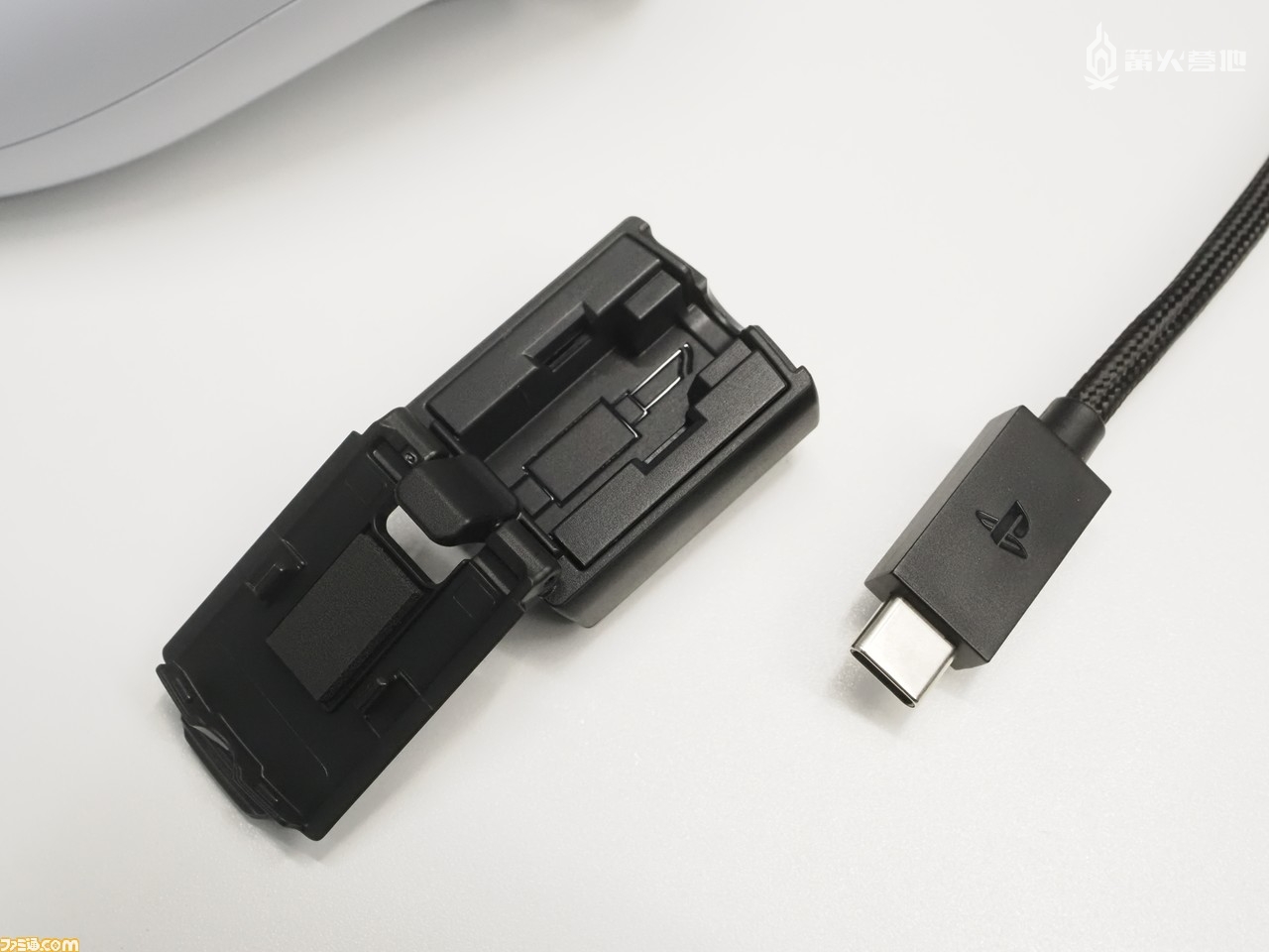 购入 DualSense Edge 附赠的 USB Type-C 数据线长达 2.8 米。图中左侧呈打开状的装置就是连接保护头，与 USB 数据线连接后能够有效防止端口弯折和连接脱落